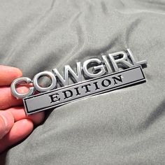 a person is holding onto a badge that says cowgirl edition on it's back