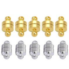 six gold and silver metal knobs with screws on each one, all in different sizes