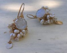 "Wedding Jewelry, Gold Filled Moonstone Earrings, Pearl Wedding Jewelry, Bridal Earrings, Moonstone Jewelry, Statement Earrings Rich and glamorous goddess moonstone earrings made of silver and gold filled, set with faceted moonstone and delicate interwoven pearls around it. A shiny gold filled handmade leaf dangle gently. Each leaf is hand crafted, and has its own unique shape. Measurements Approximately 5 cm length, 2 cm width. Materials: Stone: moonstone, pearl Metal: gold filled Each earring Wedding Jewelry Gold, Pearl Wedding Jewelry, Pearl Jewelry Wedding, Gold Wedding Jewelry, Jewelry Bridal, Jewelry Statement, Moonstone Earrings, Earrings Pearl, Moonstone Jewelry