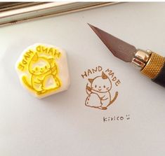 a rubber stamp with an image of a cat on it and a knife next to it