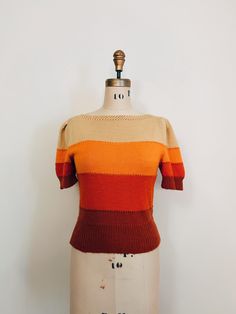 |d e s c r i p t i o n| *Y2K does 1930s *30s style handknit adorable short sleeve Fall sweater *colored layers of light yellow, orange, red, and rust  *cute puffed sleeves  *beautiful knit design at neckline  *pullover style  *very soft, likely a wool blend  |i n f o| tag: none, handmade  condition: excellent vintage condition. Some general minor piling  |m e a s u r e m e n t s| *measured flat, this sweater does have stretch* bust: 32" waist: 27" length: 19.5" sleeve length: 10" est. size: s/m Retro Knitted Brown Tops, Retro Brown Knitted Tops, Retro Crew Neck Knit Top, Retro Fitted Tops For Fall, Fitted Retro Tops For Fall, Retro Textured Knit Crew Neck Top, Retro Fall Sweater, Brown Retro Knit Sweater, Retro Brown Knit Sweater