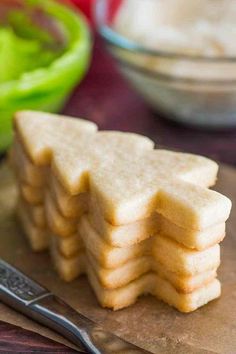 a stack of crackers sitting on top of a cutting board next to a bowl