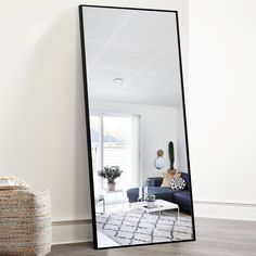 a large mirror sitting on top of a wooden floor