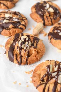 several cookies with chocolate drizzle and nuts on top