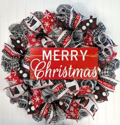 a red and black christmas wreath with the words merry christmas on it's side