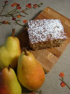 two pieces of cake and three pears on a cutting board