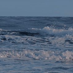 a man riding a surfboard on top of a wave in the ocean