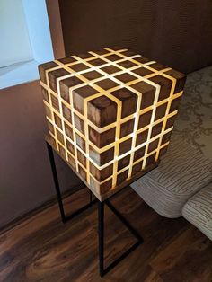 a wooden box sitting on top of a black metal stand next to a bed in a room