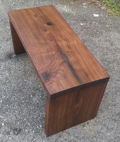 a wooden bench sitting on top of a cement ground