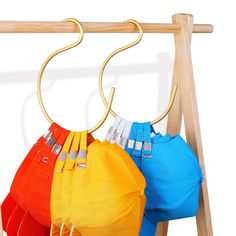 three umbrellas are hanging on a wooden rack with metal hooks and clips to hang them