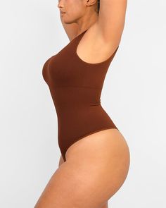 Made from recycled sculpting fabric with forward, asymmetrical cut-out detail, this bodysuit lifts and smooths. Perfect for layering under clothes or wearing alone as a super flattering all-in-one style. Why you'll love it!• Functional bodysuit with fashion.• Knitted from recycled fabric.• Built-in removable pads.• Hidden knit-in panel for 360° of tummy shaping and support.• Cool, asymmetrical cut-out detail.• Thong-cut bottom for seamless wear.• Snap closures at the bottom for easy undoing. Wedding Shapewear, Black Friday In July, Waist Trainer Workout, Cut Out Bodysuit, Going Out Looks, Low Intensity Workout, Asymmetrical Cut, Cutout Bodysuit, Eco Chic