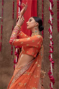 Pakistani Raw Silk Orange Lehenga Choli Dress is tangerine Raw Silk Lehenga is encrusted with pearls, Red Kora, Sitara, and naqshi in gold. It is paired up with a halter-neck choli and tangerine organza dupatta with gorgeous embroidered borders. Choli: With pure fabric heavily laden with sequins, Sitara, naqshi, and the perfect blend of traditional flamboyance and modern style in design, you need to look no further for the perfect look for your special day. Pair this traditionally chic choli wit Unstitched Orange Choli For Festivals, Unstitched Orange Choli In Traditional Drape, Traditional Orange Dress For Reception, Orange Fitted Elegant Blouse Piece, Elegant Orange Fitted Blouse Piece, Elegant Fitted Orange Blouse Piece, Unstitched Bollywood Choli In Orange, Unstitched Orange Bollywood Choli, Orange Sharara With Intricate Embroidery For Reception