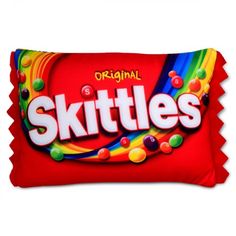 skittles candy bar on a red pillow with the word skittles printed on it