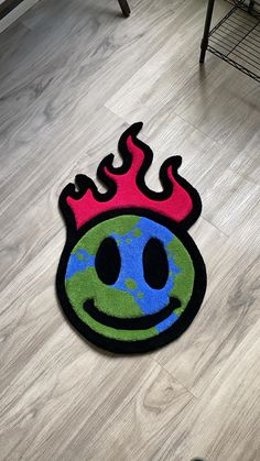 a floor mat with a smiley face on it and flames coming out of the top