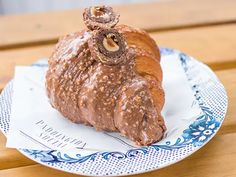 a piece of chocolate pastry sitting on top of a paper plate covered in icing