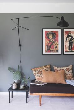 a living room with grey walls and pictures on the wall, including a couch in front of a coffee table