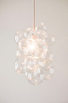 a chandelier hanging from a ceiling in a room with white walls and flooring