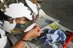 a person is using scissors to cut out the paper on top of a newspaper page