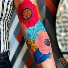 a woman's arm with colorful flowers on it