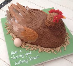 a cake shaped like a chicken sitting on top of a green plate with an egg in the nest