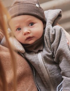 a baby wearing a brown hat and coat