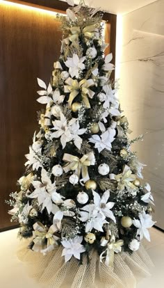 a christmas tree with white and gold decorations