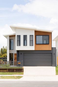 a two story house with wood and white siding