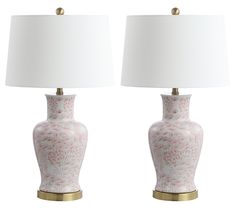 two pink and white vases with lamps on them