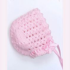 a pink crocheted hat with a bow on it