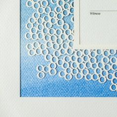 a blue and white paper with circles on the bottom, in front of a square frame