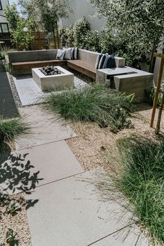 a concrete bench sitting next to a fire pit on top of a cement slab covered in grass