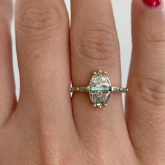 a woman's hand with a ring on it and a diamond in the middle