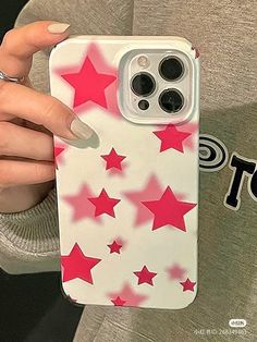 a woman holding up her phone case with red stars on it