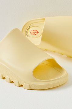 A pre- and post-workout essential, these sporty slides are featured in a smooth fabrication and slip-on style with a dreamy, cushioned insole, a single wide strap, and bold traction details perfect for taking you from the studio to the street. * Buti logo detailing * Flat-sole style * Lightweight design **Sizing:** * S: EU 35/36, US 5/6 * M: EU 37/38, US 7/8 * L: EU 39/40, US 9/10 * XL: EU 41/42, US 11/12 **Fit:** This style runs true to size; if in between sizes, we suggest sizing up. **About T Foam Slide Sandals With Rubber Sole, Foam Slides With Rubber Sole, Spring Foam Slides With Non-slip Details, Sporty Slip-resistant Slides For Spring, Spring Foam Slides With Non-slip Design, Spring Foam Slip-on Slides, Spring Non-slip Foam Slides, Functional Summer Streetwear Slides, Comfortable Slip-resistant Spring Slides