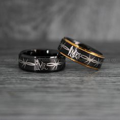 two black and gold wedding bands with the words mr and mrs engraved on them