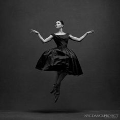 a woman in a black dress is flying through the air