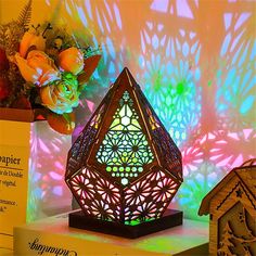 a decorative lamp sitting on top of a table next to a box with flowers in it