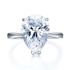 a pear shaped diamond engagement ring on a white background