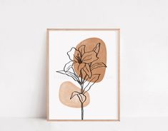 an art print with flowers on it in a wooden frame next to a white wall