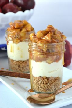 two jars filled with dessert sitting on top of a white plate