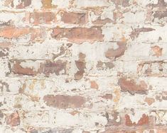 an old brick wall with white and brown paint