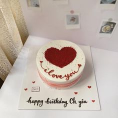 a birthday cake with the word love you written on it and a heart - shaped frosting