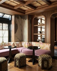 a living room filled with furniture next to a window covered in wooden paneled walls