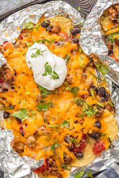 an image of mexican food on foil with sour cream