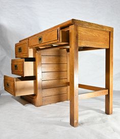 a wooden desk with three drawers on one side and an open drawer on the other