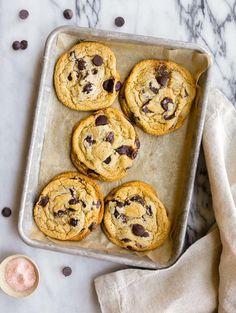 six chocolate chip cookies on a baking sheet