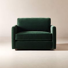 a green chair sitting on top of a white floor in front of a beige wall