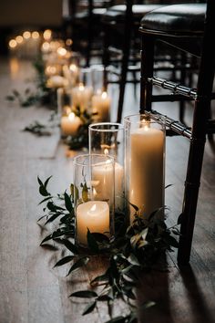 candles and greenery are lined up on the floor