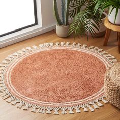 a round rug on the floor next to a potted plant