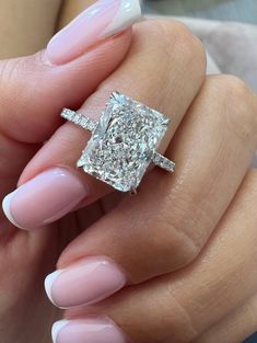 a woman's hand with pink manicured nails and an engagement ring